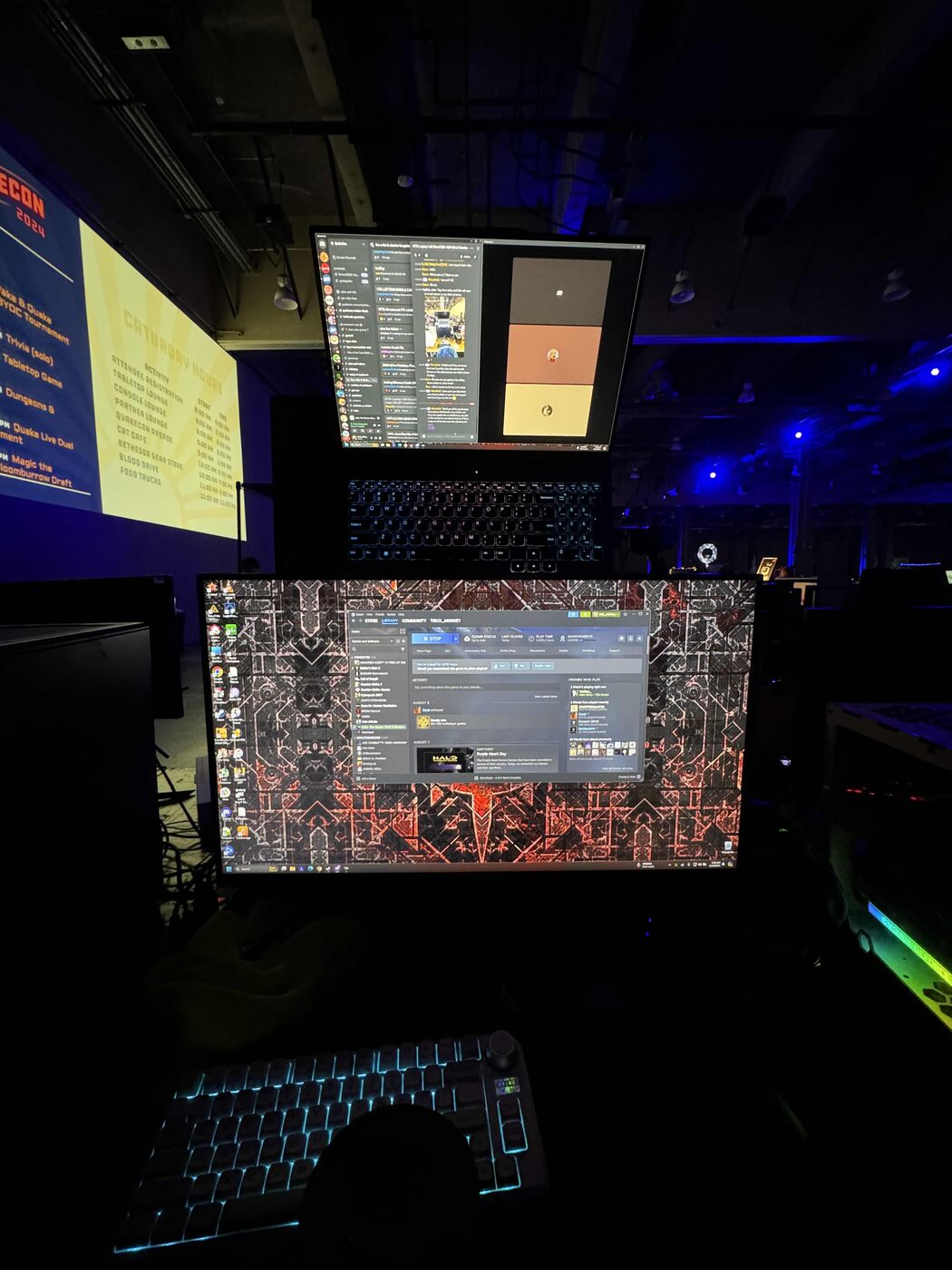LAN Stand dual-screen setup at a convention, lights out